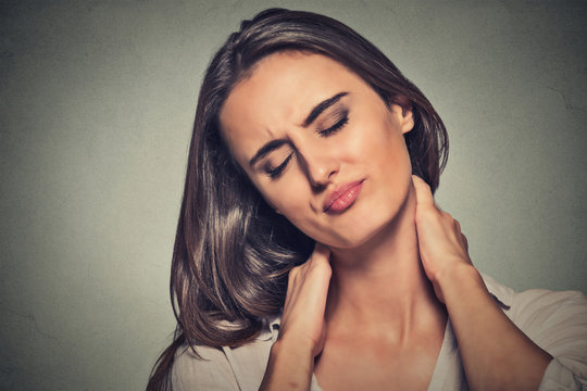 tired woman massaging her painful neck