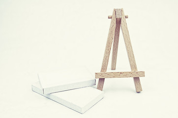 retro look white canvas and wood stand. yellow and grain background