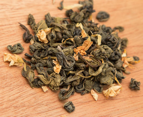 dry green tea with jasmine on a wooden background
