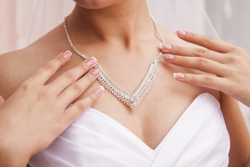 Bride holding necklace