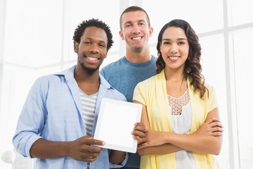 Fototapeta premium Portrait of smiling colleagues presenting tablet computer