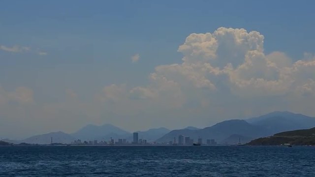 panorama of vietnamese city resort from azure seaside against white clouds blue sky and mountains at sunrise