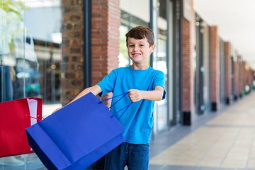 Young boy playing with shopping bags