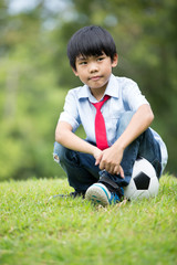 Obraz premium Little asian boy with football at the park