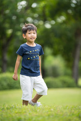 Portrait of asian boy in the park green background,
