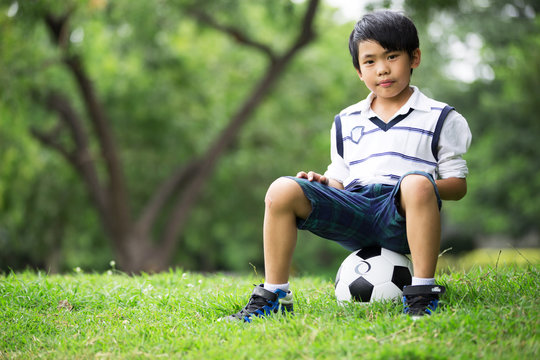 Little asian boy with football at the park