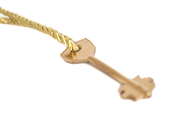 Golden key hanging on gold chain isolated over white