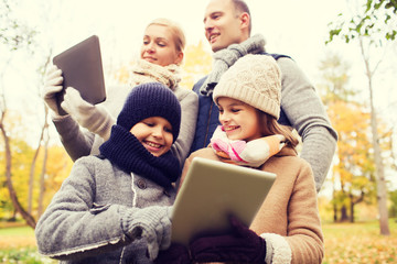 happy family with tablet pc in autumn park