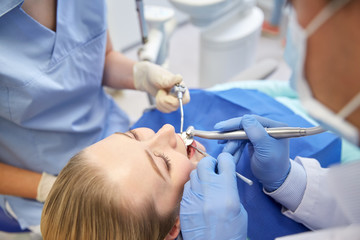 close up of dentist treating female patient teeth