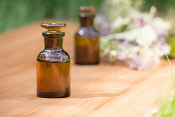 essential oil in little bottle and medical flowers herbs