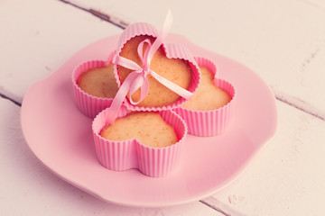 Cupcakes in pink forms for baking (in the form of heart).