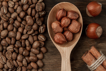 Background coffee. Roasted coffee, hazelnut, cinnamon on an old wooden background