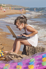 Девочка с ноутбуком на пляже
