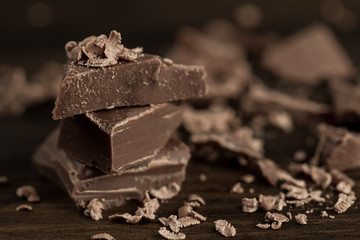 Broken chocolate bar on wooden background, close-up