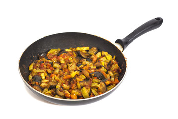 Frying pan with vegetables isolated on white