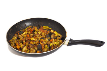 Frying pan with vegetables isolated on white