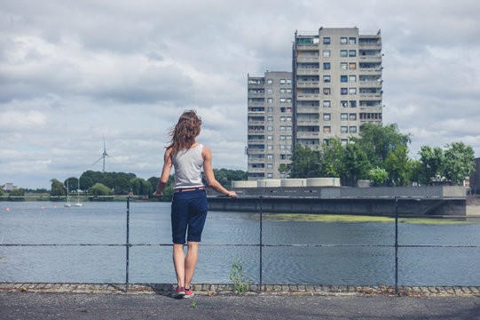 Young woman standing by marina in urban area