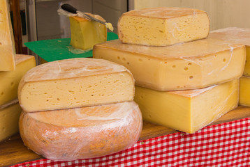 Blocks of fresh yellow cheese for sale on stall