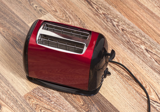 Red toaster on wooden background