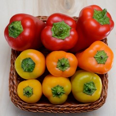 Peperoni dentro un cestino di vimini sul legno