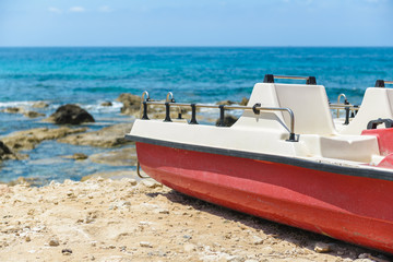 Red and white boat on the beach on a Mediterranean island