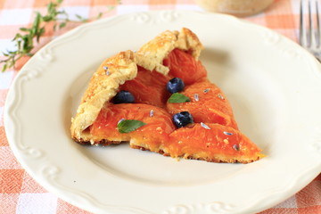 Simple crusty slice pie of short pastry with fresh apricots, blu