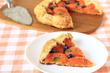 Simple crusty slice pie of short pastry with fresh apricots, blu