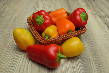 Peperoni dentro un cestino di vimini sul legno