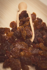 Vintage photo, Brown raisins with spoon on wooden table, healthy eating