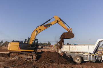 Fototapeta na wymiar Earthworks excavator machine bucket bin earth loading truck bin