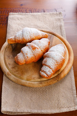 Croissant served on wooden plate