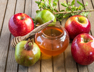 Honey, apples and pomegranates on wood deck for Rosh Hashana celebration.