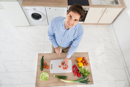 Man Chopping Vegetables In Kitchen