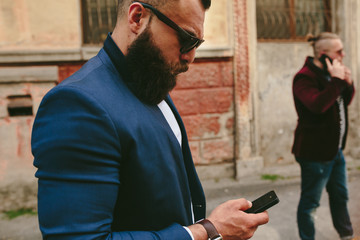 Bearded businessman looking at phone