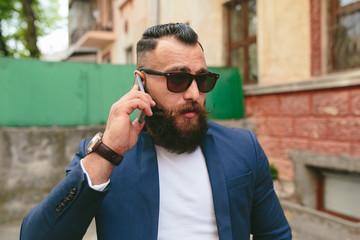 Bearded businessman looking at phone