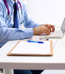 Doctor at work, close up of male doctor typing on a laptop