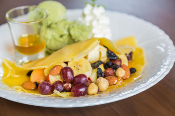 Pancake and fruit with ice cream on table