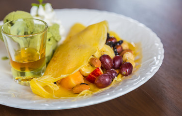 Pancake and fruit with ice cream on table