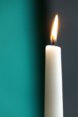 white candle with grey and turquois background