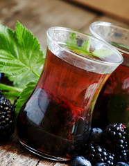 Hot black tea with berries, selective focus