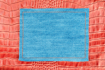Denim frame lies on a red crocodile skin