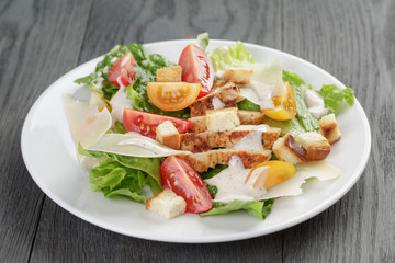 caesar salad with chicken on oak table