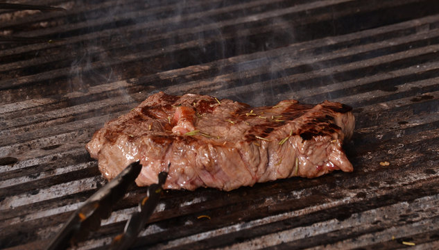 Cocinando bistec, carne a la Parrilla.
