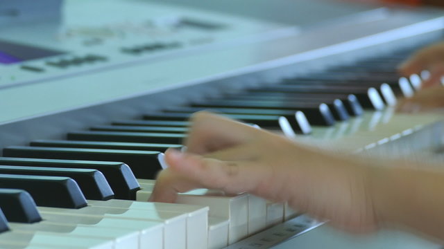 Close up of child hands is playing on electone 