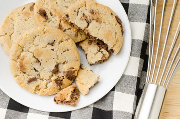 Homemade chocolate cookies on white plate and fabric