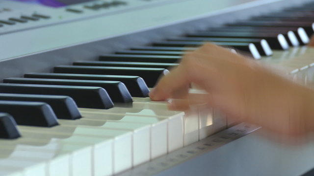 Close up of child hands is playing on electone 