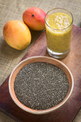 Chia seeds (lat. Salvia hispanica) photographed with natural light. Chia seed is considered a superfood (Selective Focus, Focus in the middle of the bowl and the front rim of the glass)