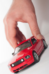 Close-up of a man's hand with a red car