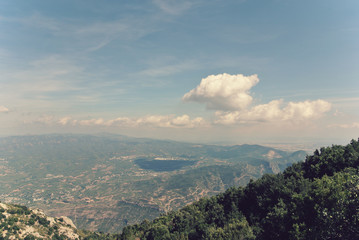 Fototapeta premium Panoramic view from the top of Montserrat mountain, located close to Barcelona in Catalonia, Spain. Image filtered in faded, washed out, retro style with soft focus; nostalgic vintage travel concept.