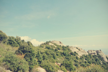 Rugged landscape of the Montserrat mountain, Catalonia, on a sunny afternoon. Image filtered in faded, washed out, retro, Instagram style with soft focus; nostalgic vintage travel concept.